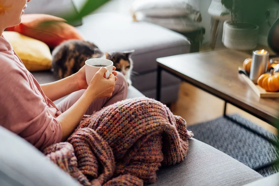 Woman sitting on the couch drinking a coffee